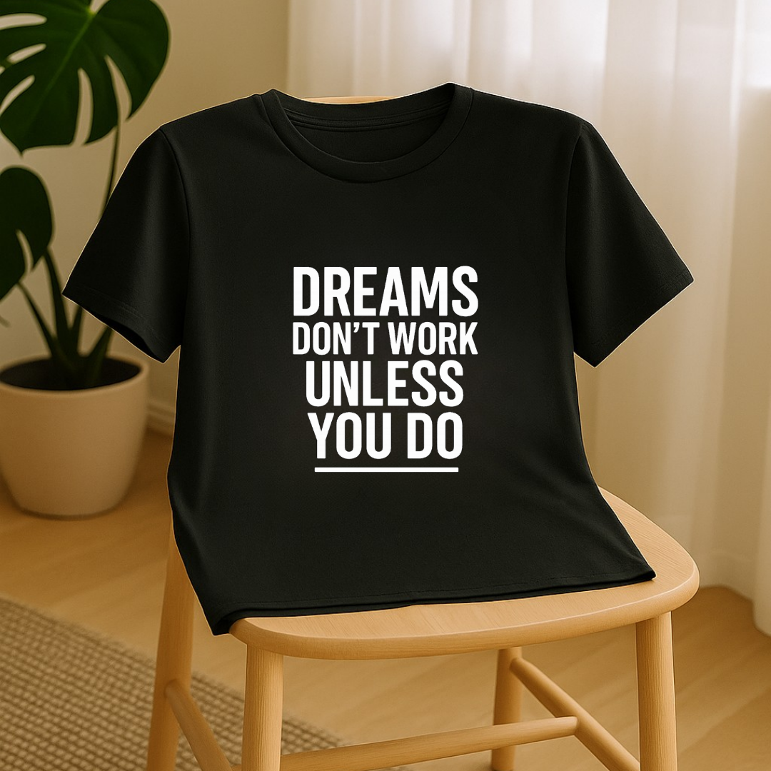 Black motivation t-shirt draped over chair featuring Dreams Don’t Work Unless You Do quote