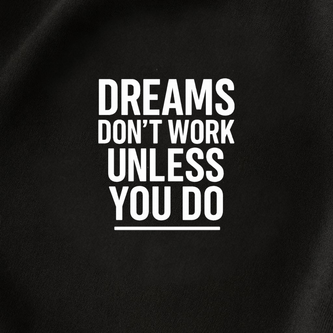 Close-up of Dreams Don’t Work Unless You Do text printed on black t-shirt fabric