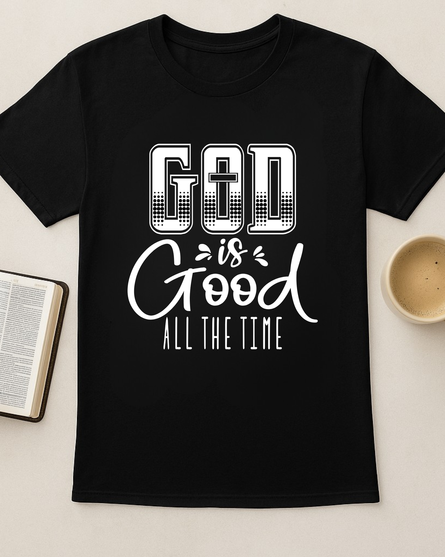 Black Christian God Is Good All The Time t-shirt displayed flat with an open Bible and a cup of coffee.
