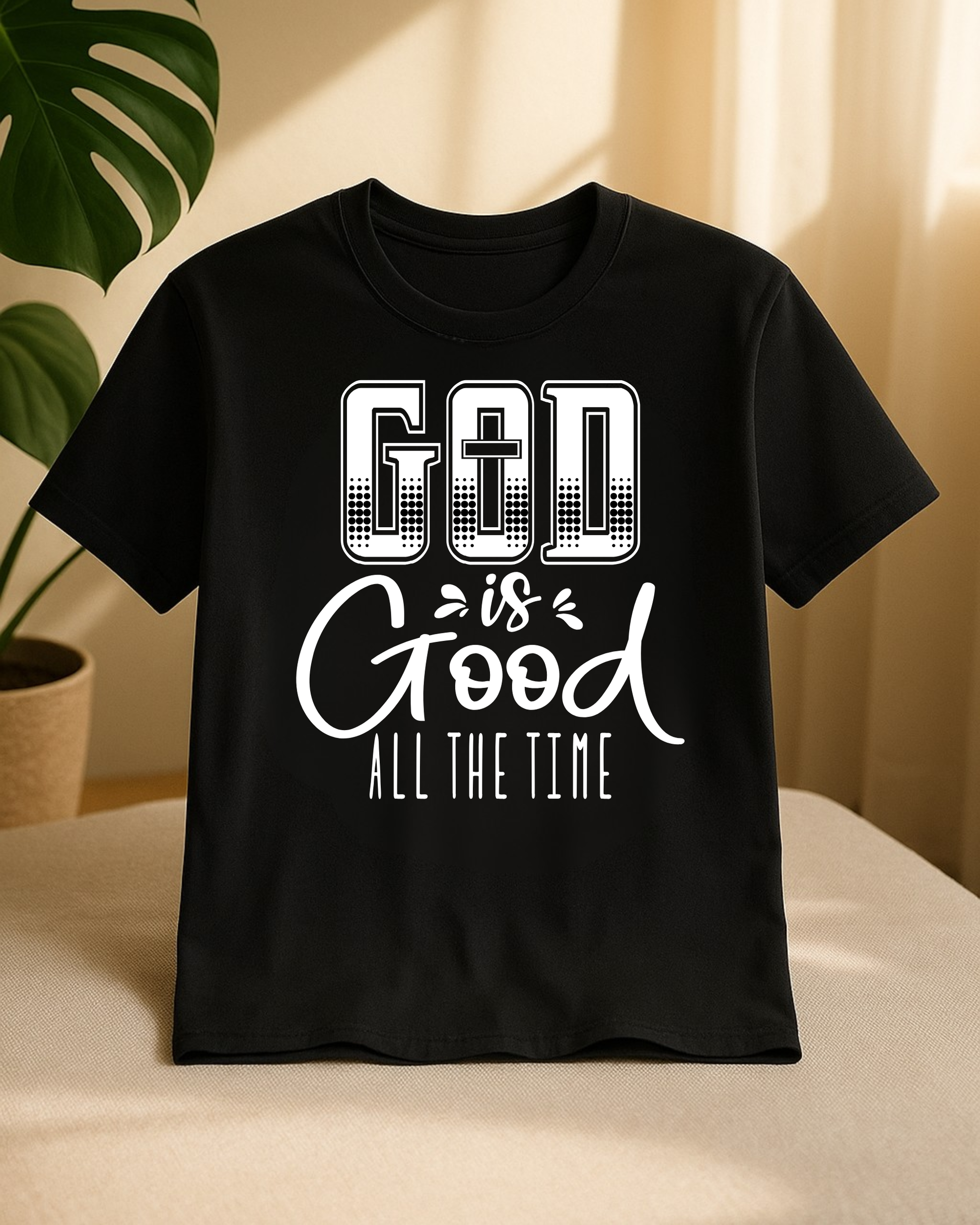 Black Christian God Is Good All The Time t-shirt displayed on a chair with a houseplant in the background.