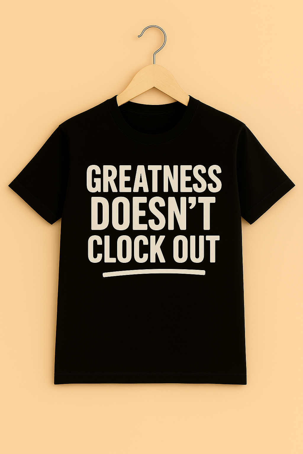 Black t-shirt with 'Greatness Doesn't Clock Out' text on hanger with a beige background