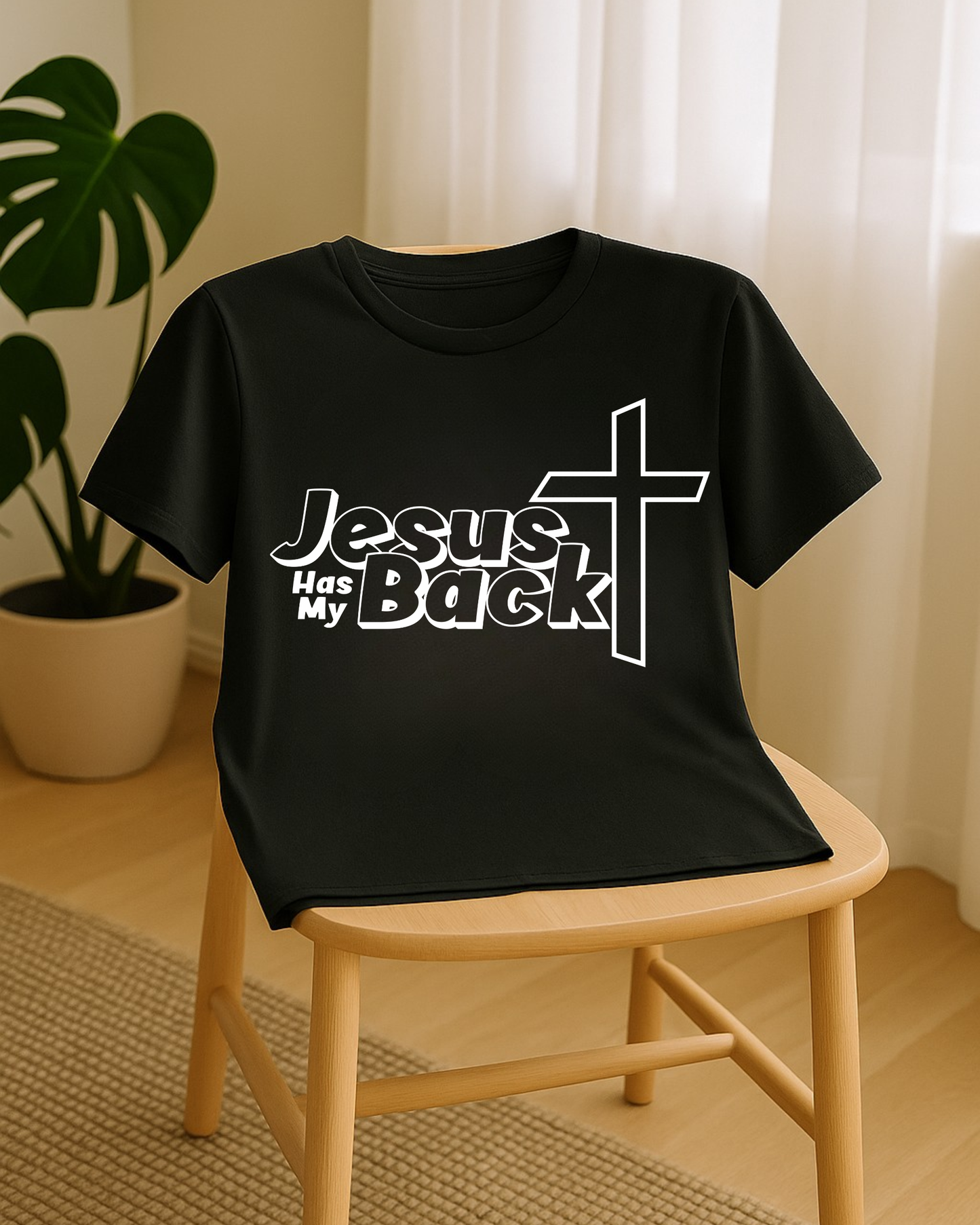 Black “Jesus Has My Back” Christian T-shirt displayed on chair in natural light
