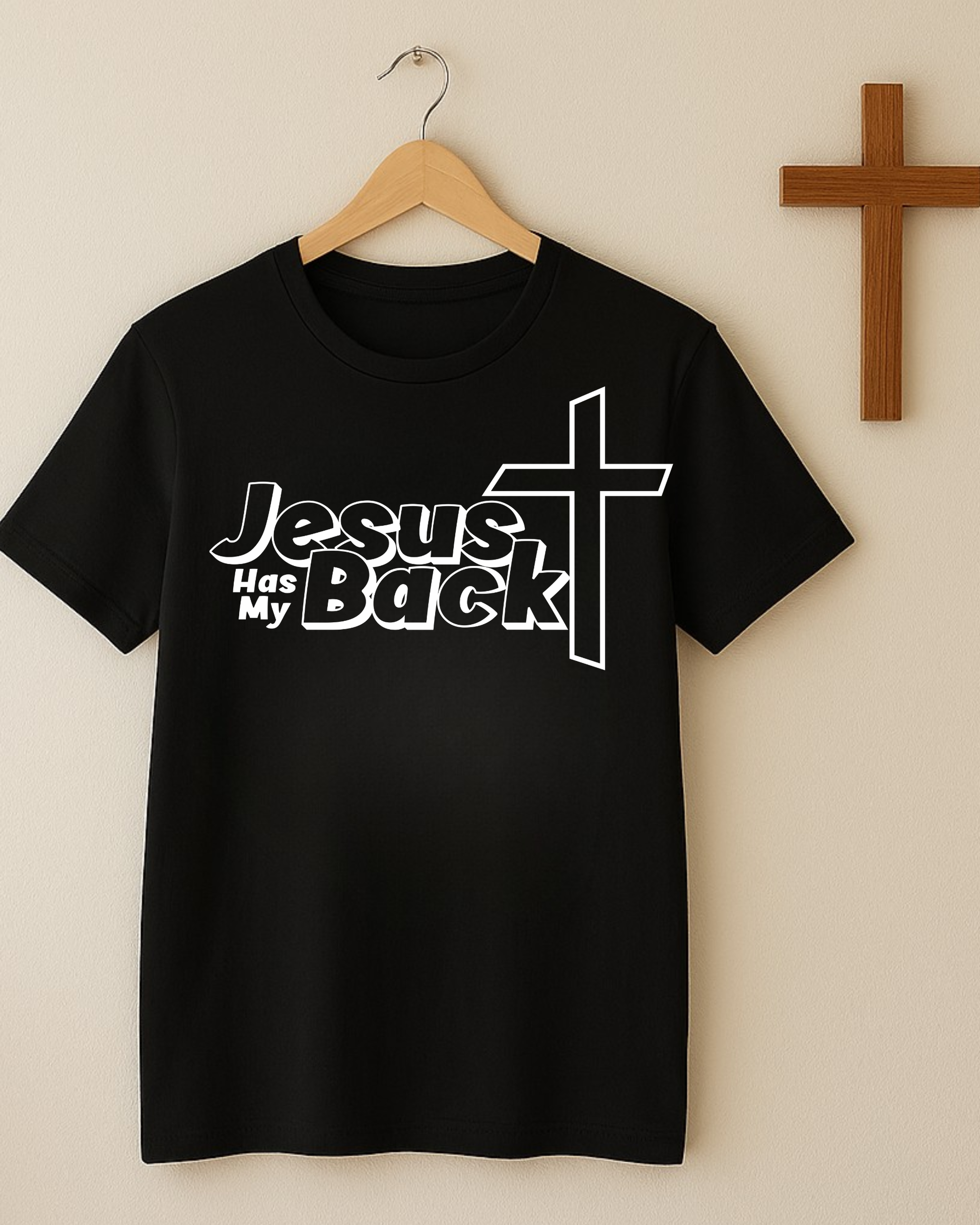 Black “Jesus Has My Back” Christian T-shirt hanging on wall beside wooden cross