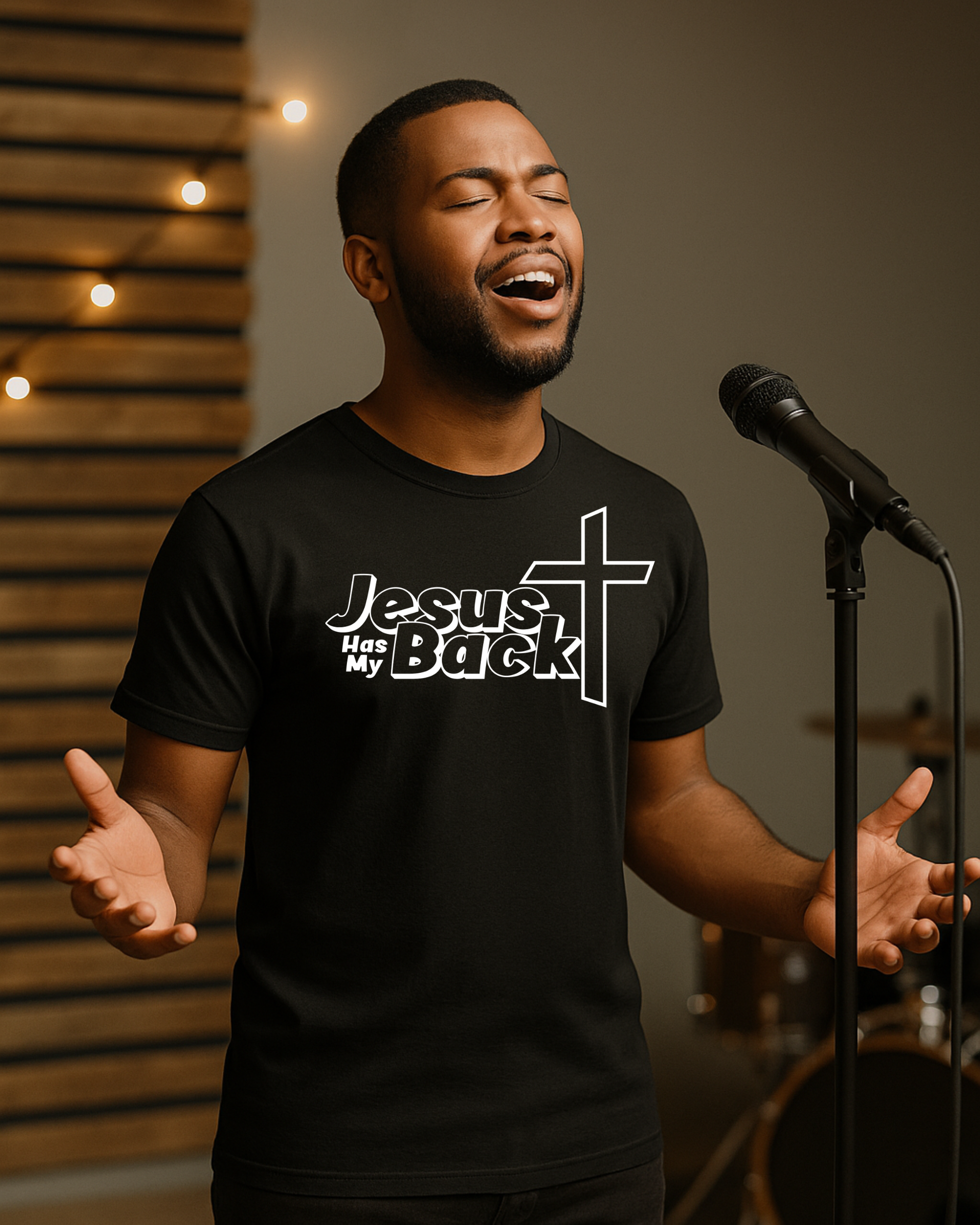 Man singing while wearing black “Jesus Has My Back” Christian T-shirt