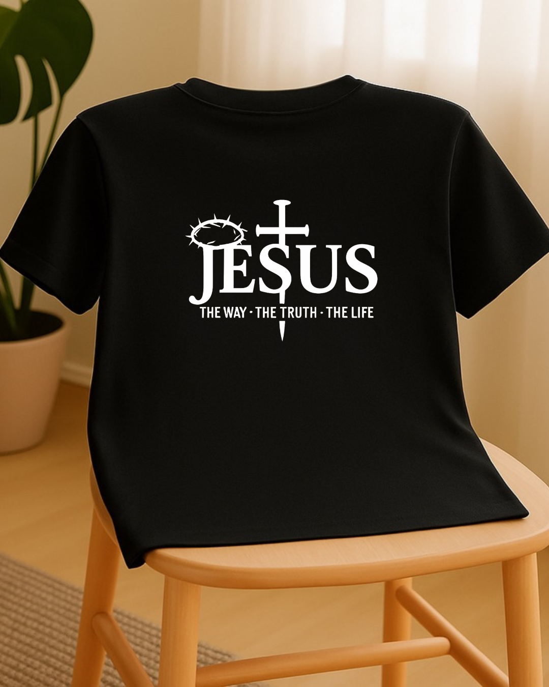 Black Christian T-shirt with Jesus The Way The Truth The Life back design displayed on chair
