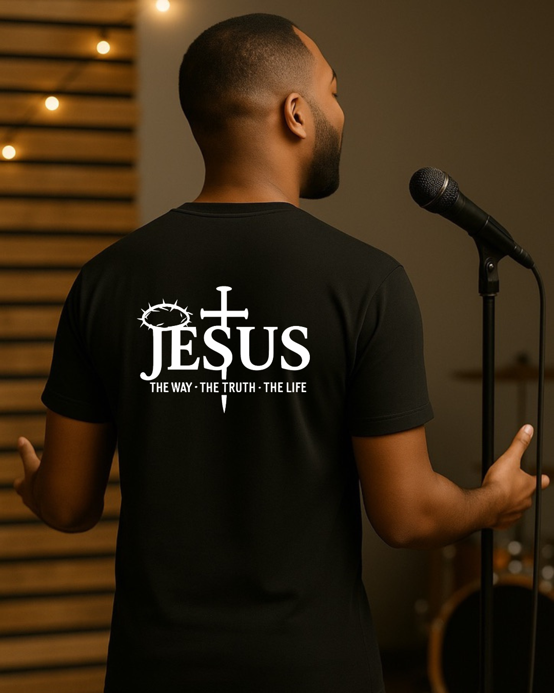 Man wearing black Christian T-shirt with Jesus The Way The Truth The Life design on the back during worship