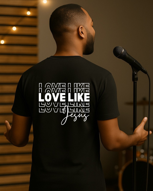 Man wearing black “Love Like Jesus” Christian T-shirt in a stage setting, faith-based inspirational apparel