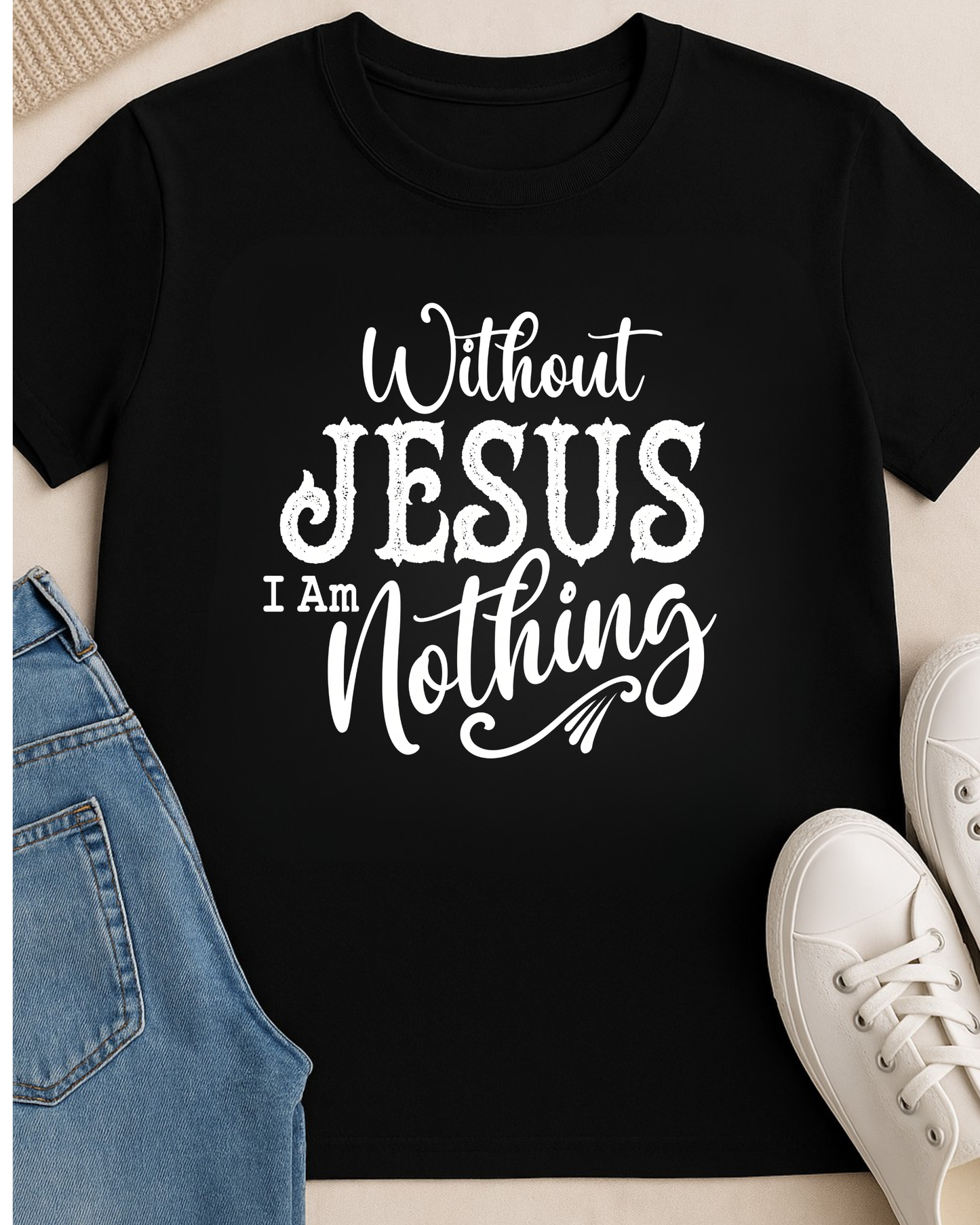 Black Christian T-shirt displayed with denim jeans and white sneakers featuring the quote “Without Jesus I Am Nothing” in bold white lettering.