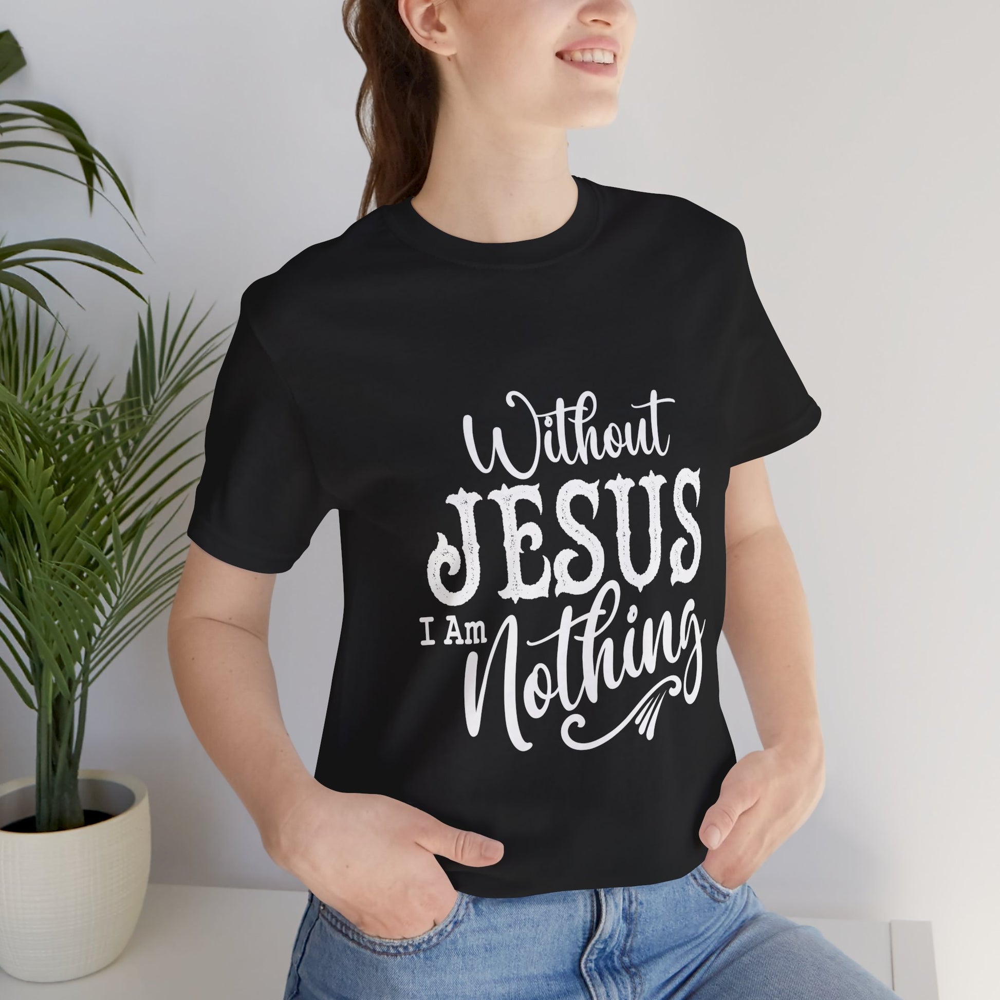Person wearing a black t-shirt with 'Without JESUS I Am Nothing' text, standing indoors.